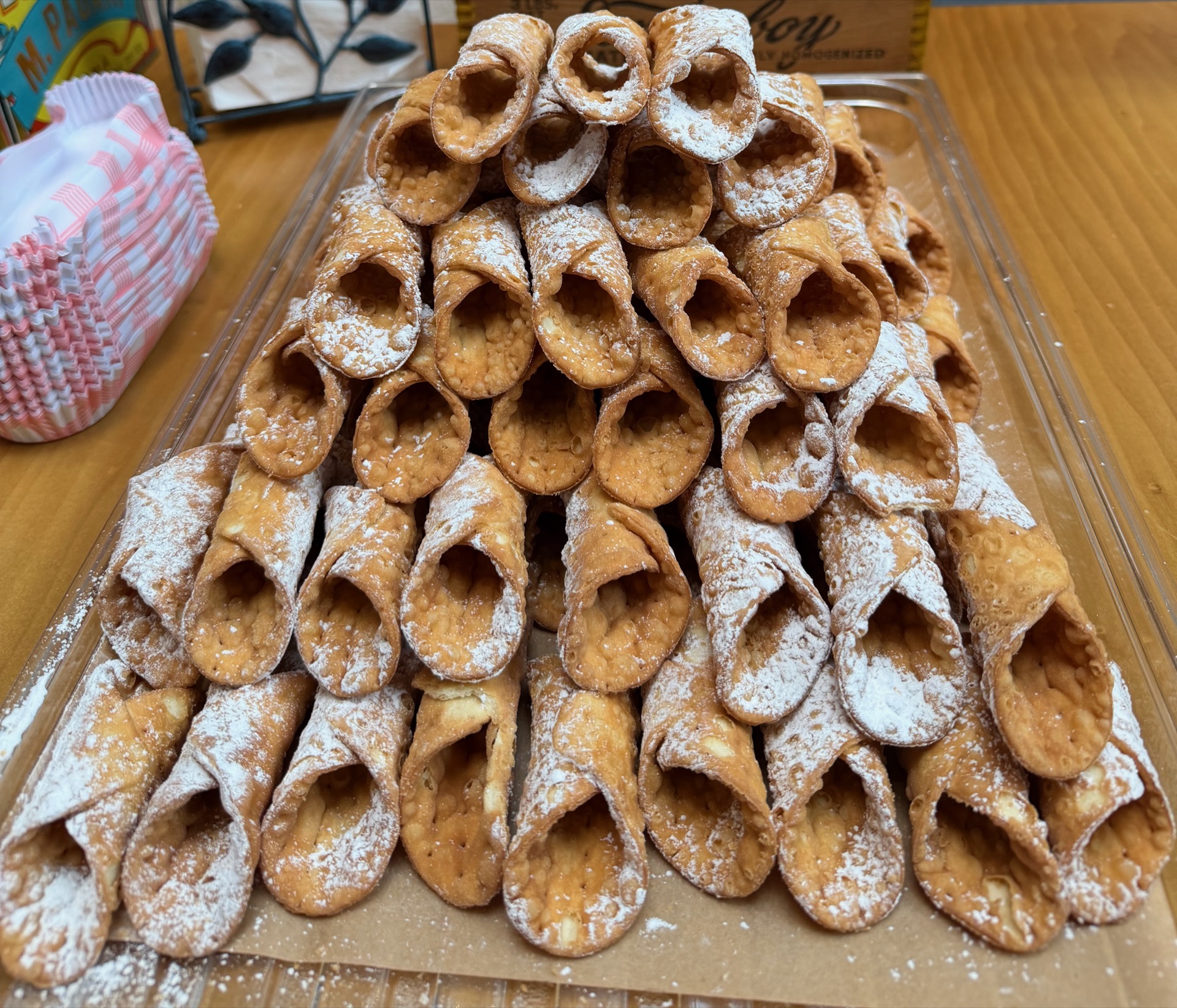 A pyramid of cannoli shells dusted with powdered sugar displayed at a Blue Bird event