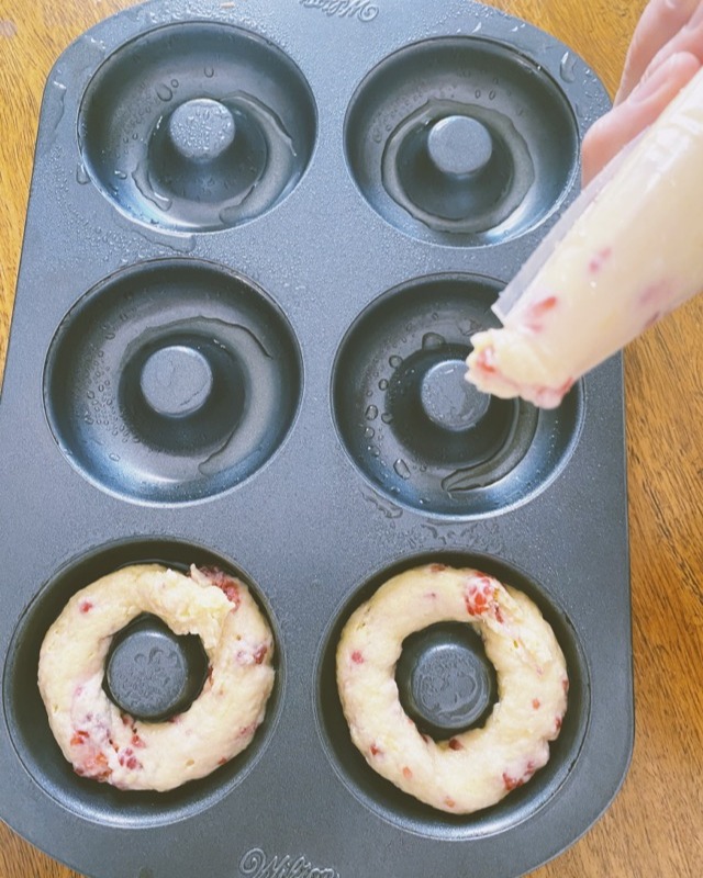 Piping batter into the donut molds